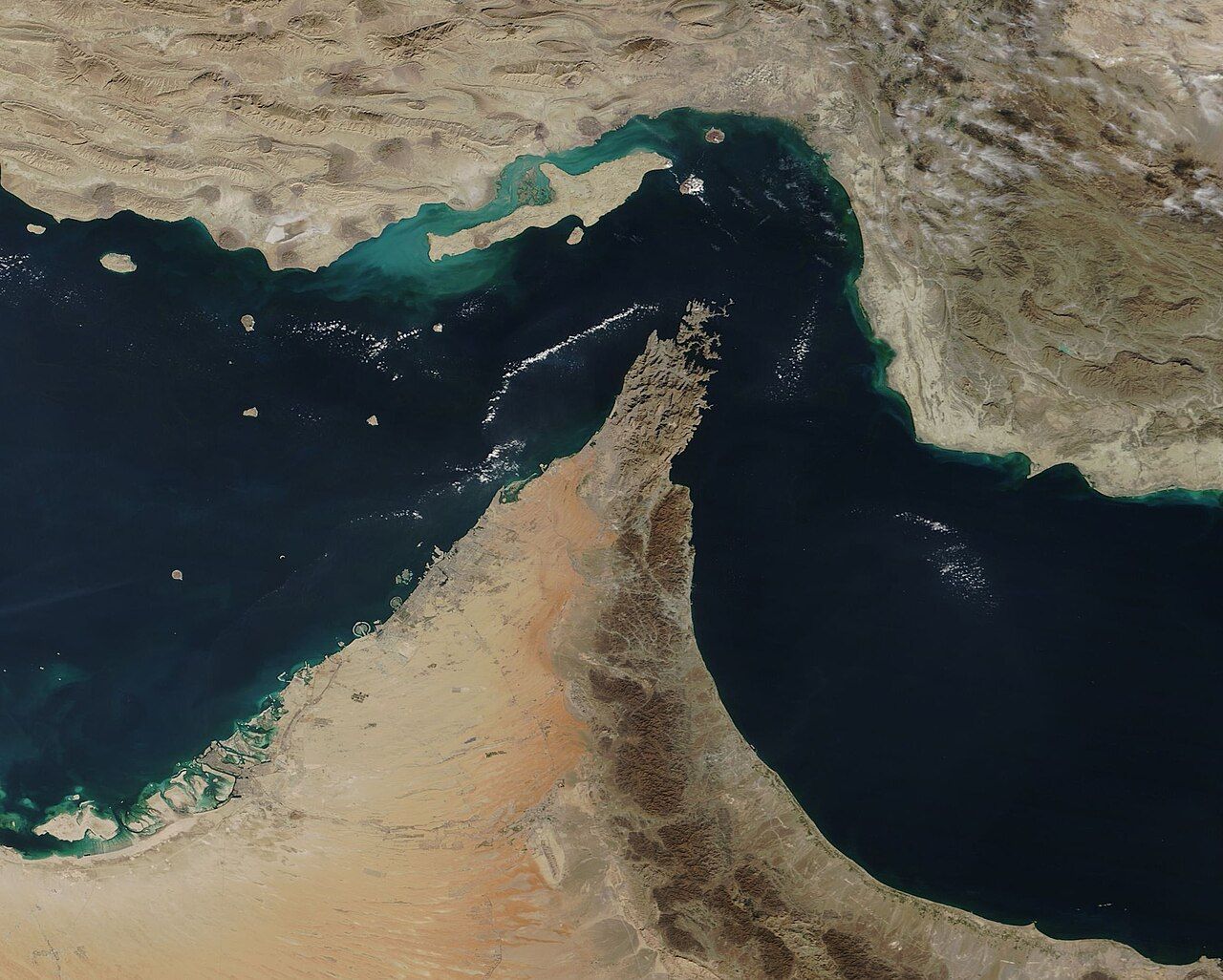 Satellite image of the Strait of Hormuz, showing Iran to the north and the Musandam Peninsula of Oman jutting into the narrow waterway.